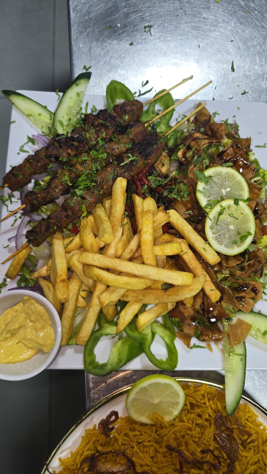 Grilled lamb skewers with fries, salad and lemon