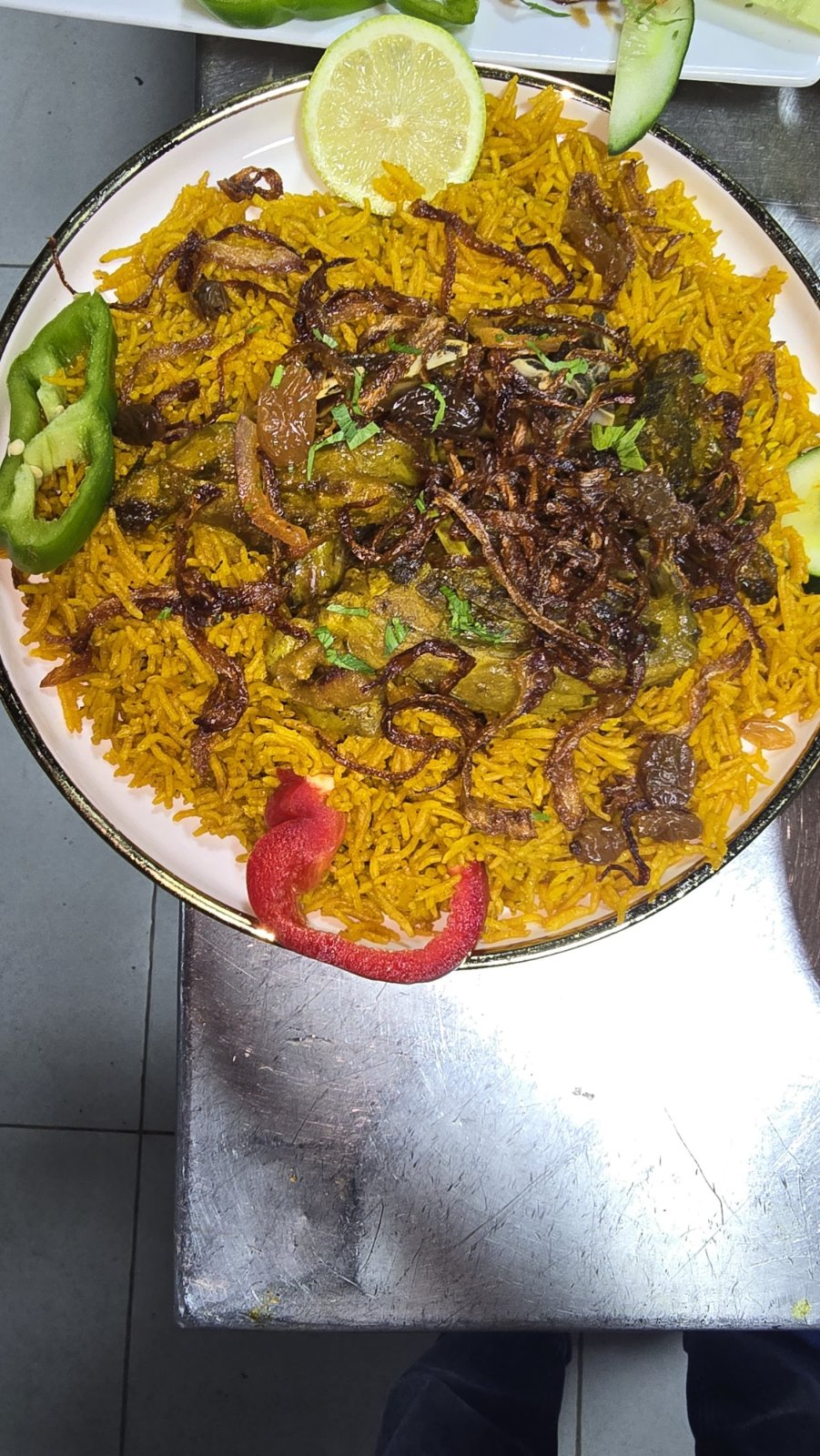 Kabsa rice with tender meat, raisins, fried onions and chili