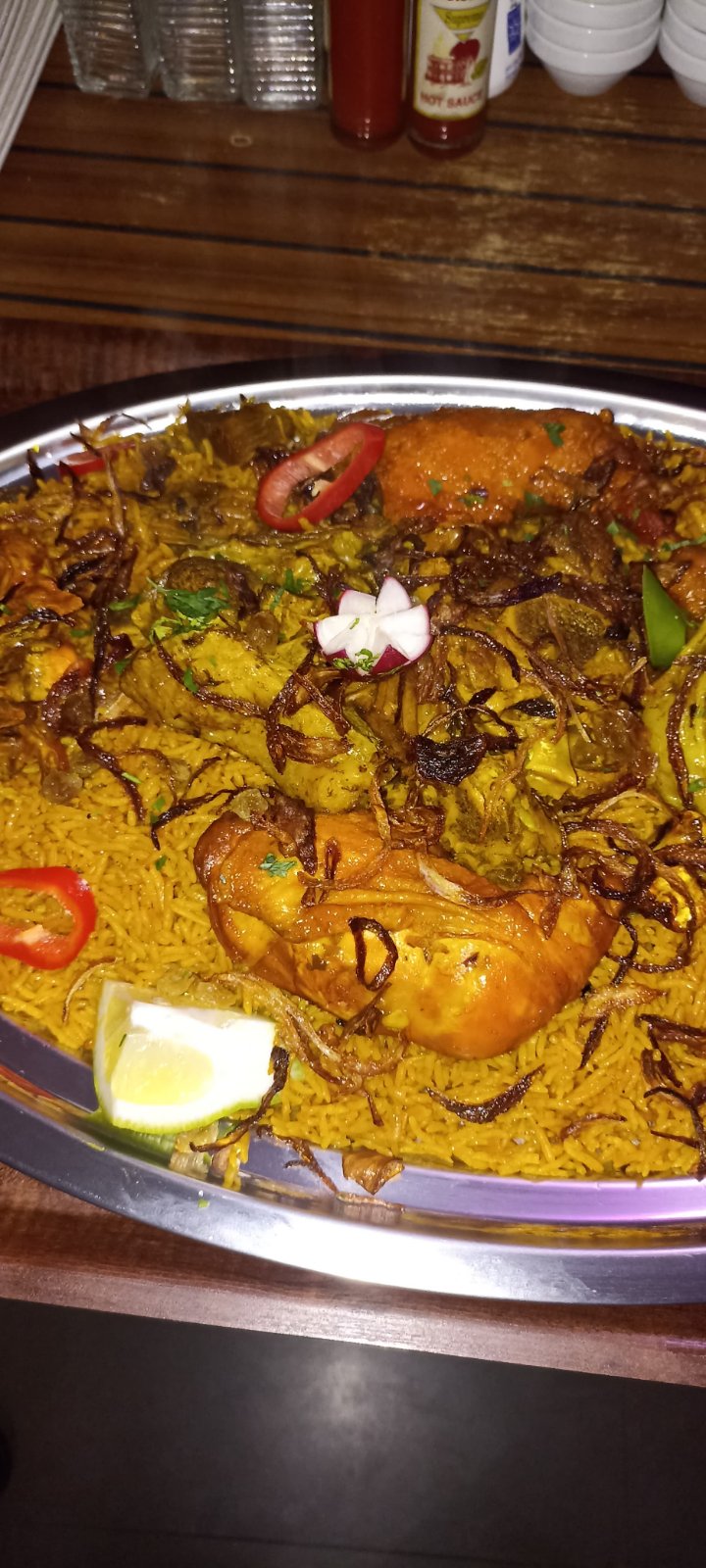 Chicken mandi platter with saffron rice, chili and lemon