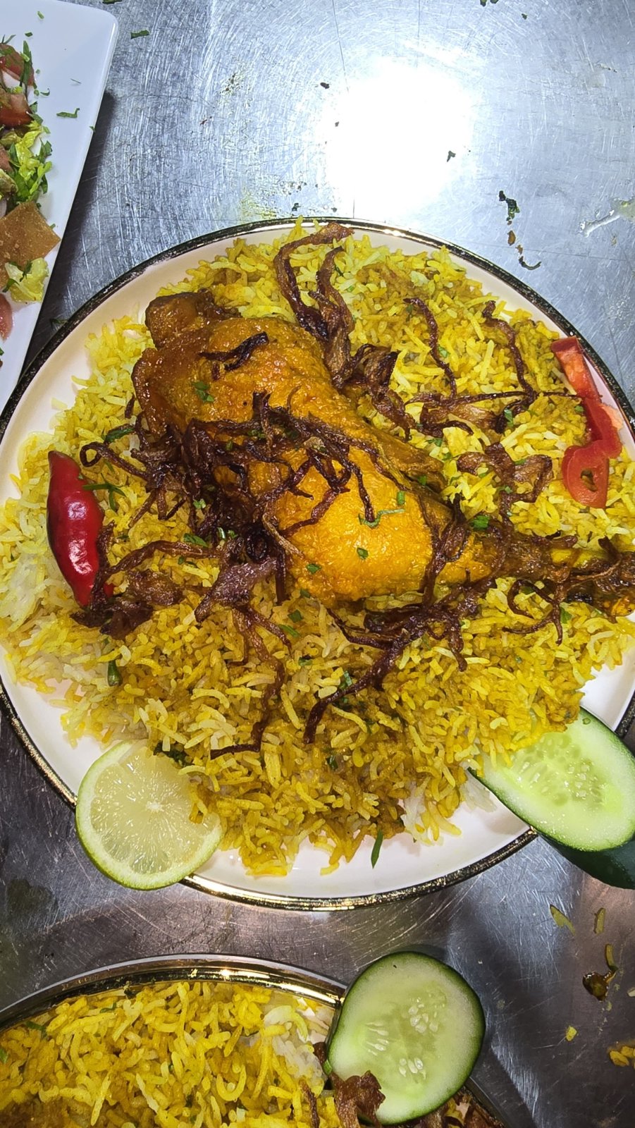 Chicken quarter over saffron rice with cucumber and lemon
